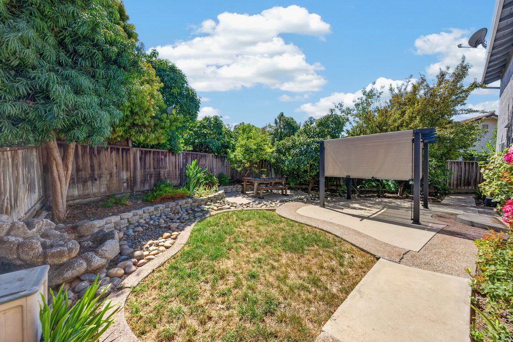 Backyard with mature trees, landscaping, and fruit trees at 4048 Victoria Park